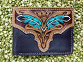 Men’s Tackrus Challenger bifold leather wallet in black and brown with hand-tooled turquoise feather design, durable genuine leather, and multiple card slots with ID window - 18FKW59. Available at Blair's Western Wear, Marble Falls, TX.