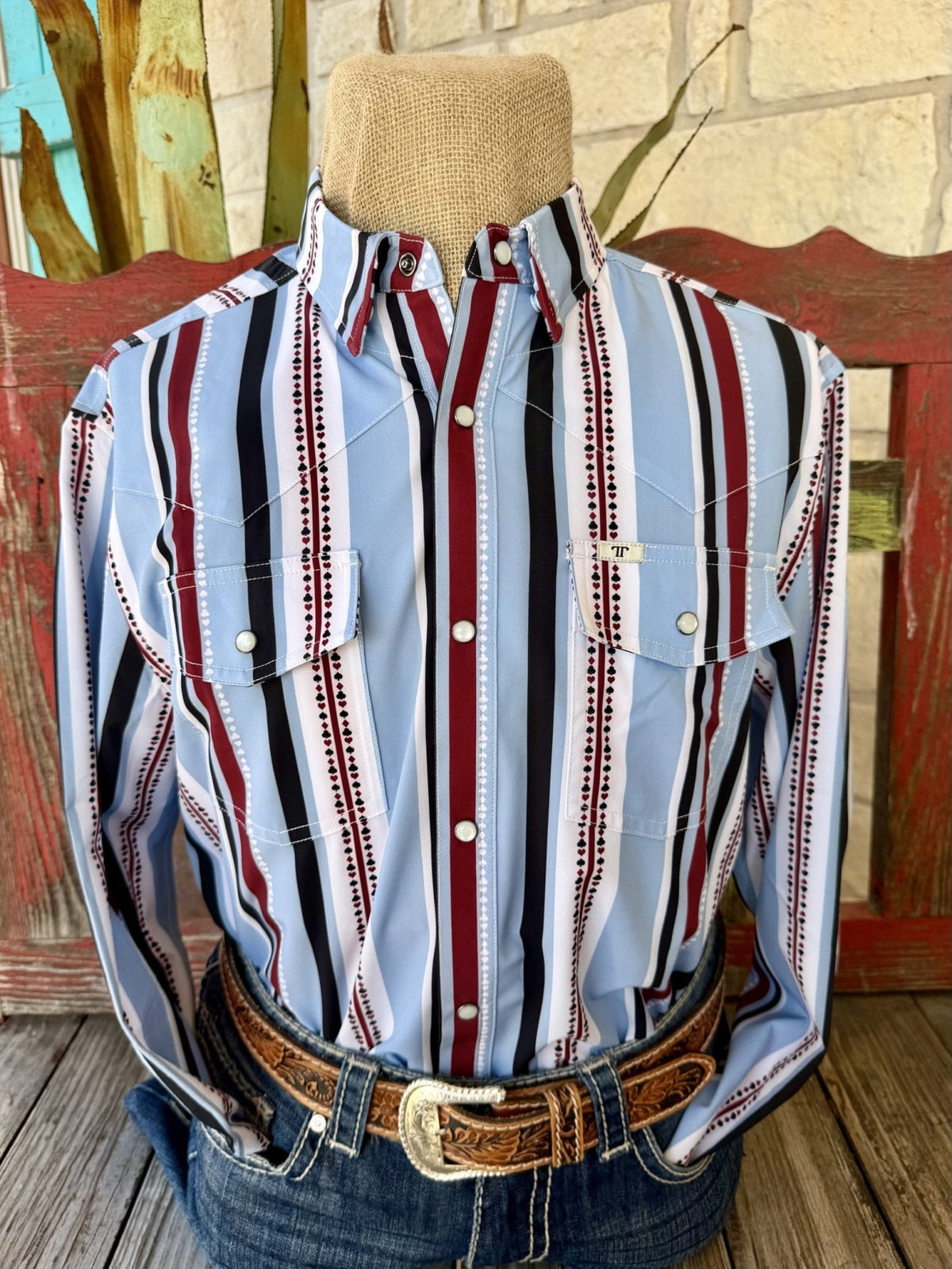 Men's light blue long sleeve Western snap shirt with wine, black, and white vertical stripes, small playing-card suit motifs, pointed collar, and two snap-flap chest pockets — Blair's Western Wear Marble Falls TX