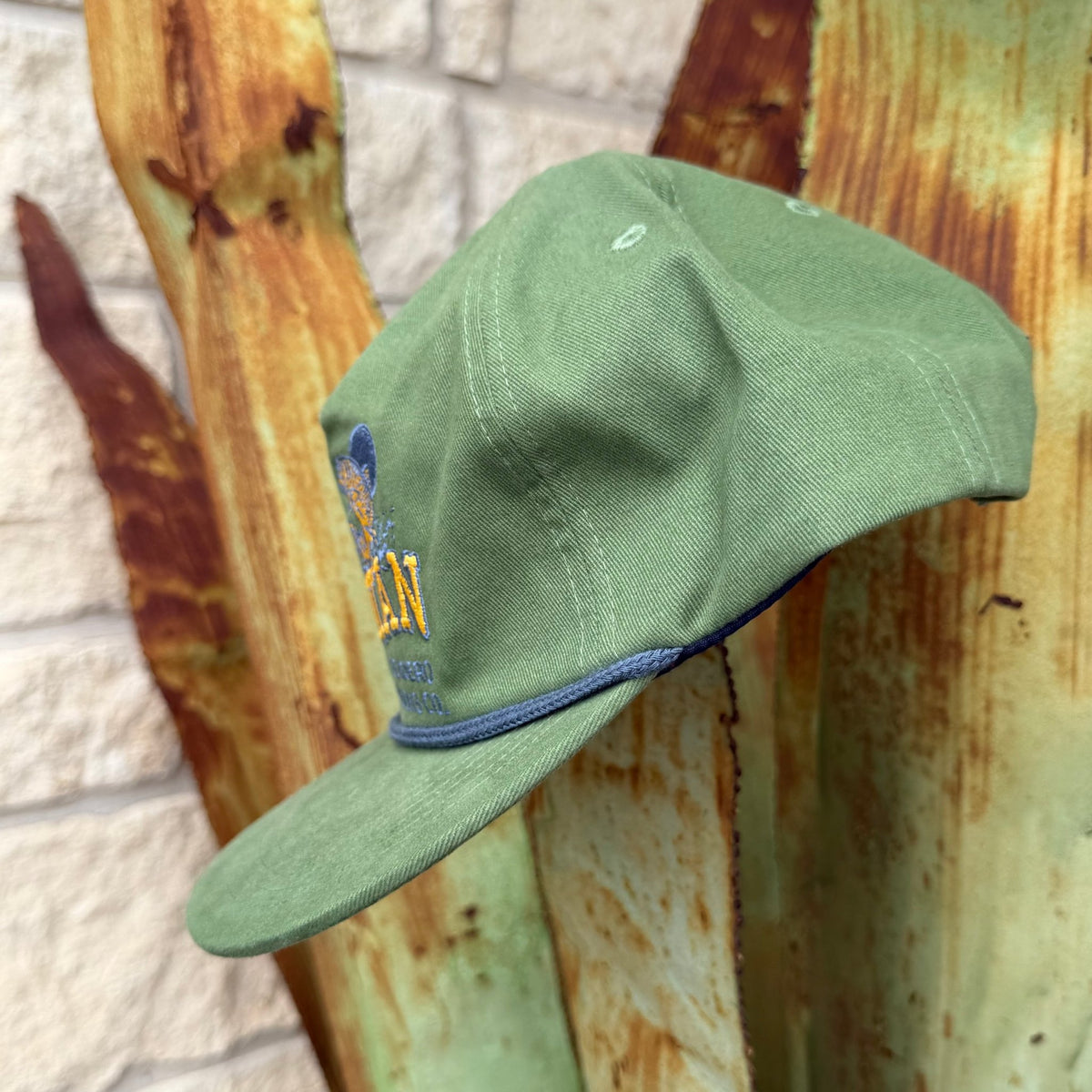 An olive green cap with a blue embroidered logo and yellow lettering, 