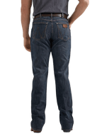 Rear view of a person wearing dark blue denim jeans with a brown leather patch on the back pocket, paired with a dark gray t-shirt and brown belt, against a plain white background.
