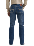Rear view of a person wearing blue denim jeans with a beige long-sleeve shirt, shown against a plain white background.