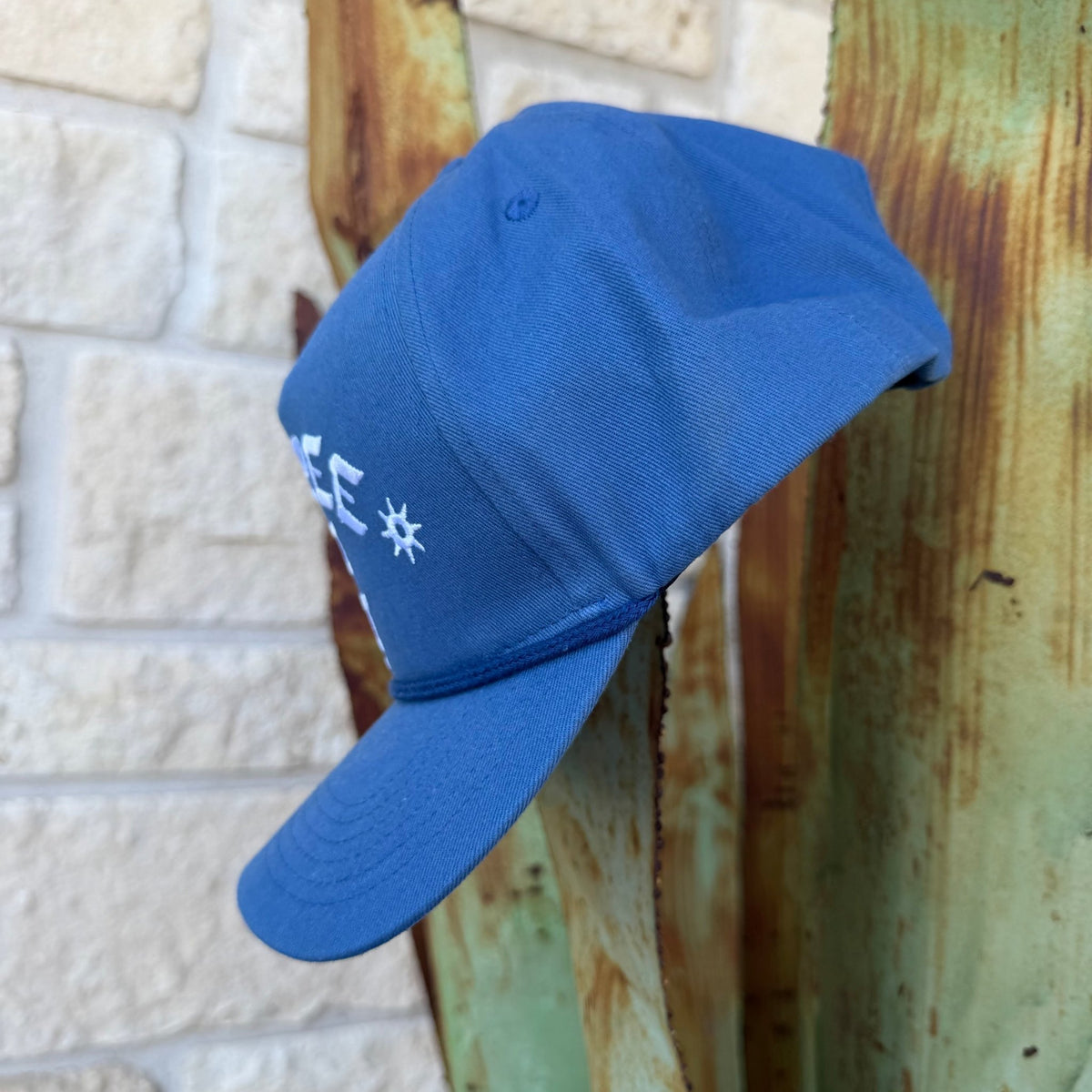 A blue cap with white embroidered lettering 