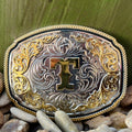 Montana Silversmiths Western Belt Buckle in silver and gold, featuring intricate engravings and a prominent 'T' initial - A1047T. Available at Blair's Western Wear, Marble Falls, TX.