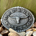 Montana Silversmiths Buckle Steerhead in silver, detailed with a roped border and branded symbols - A542S. Available at Blair's Western Wear, Marble Falls, TX.