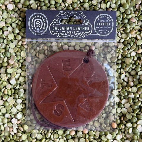Callahan Leather Air Freshener Texas Star Flag in Brown, crafted from full-grain vegetable-tanned leather, infused with signature leather scent, featuring a round medallion design with embossed Texas star and "TEXAS" lettering, includes hanging cord - AFRVTFBRWLTH. Available at Blair's Western Wear, Marble Falls, TX.