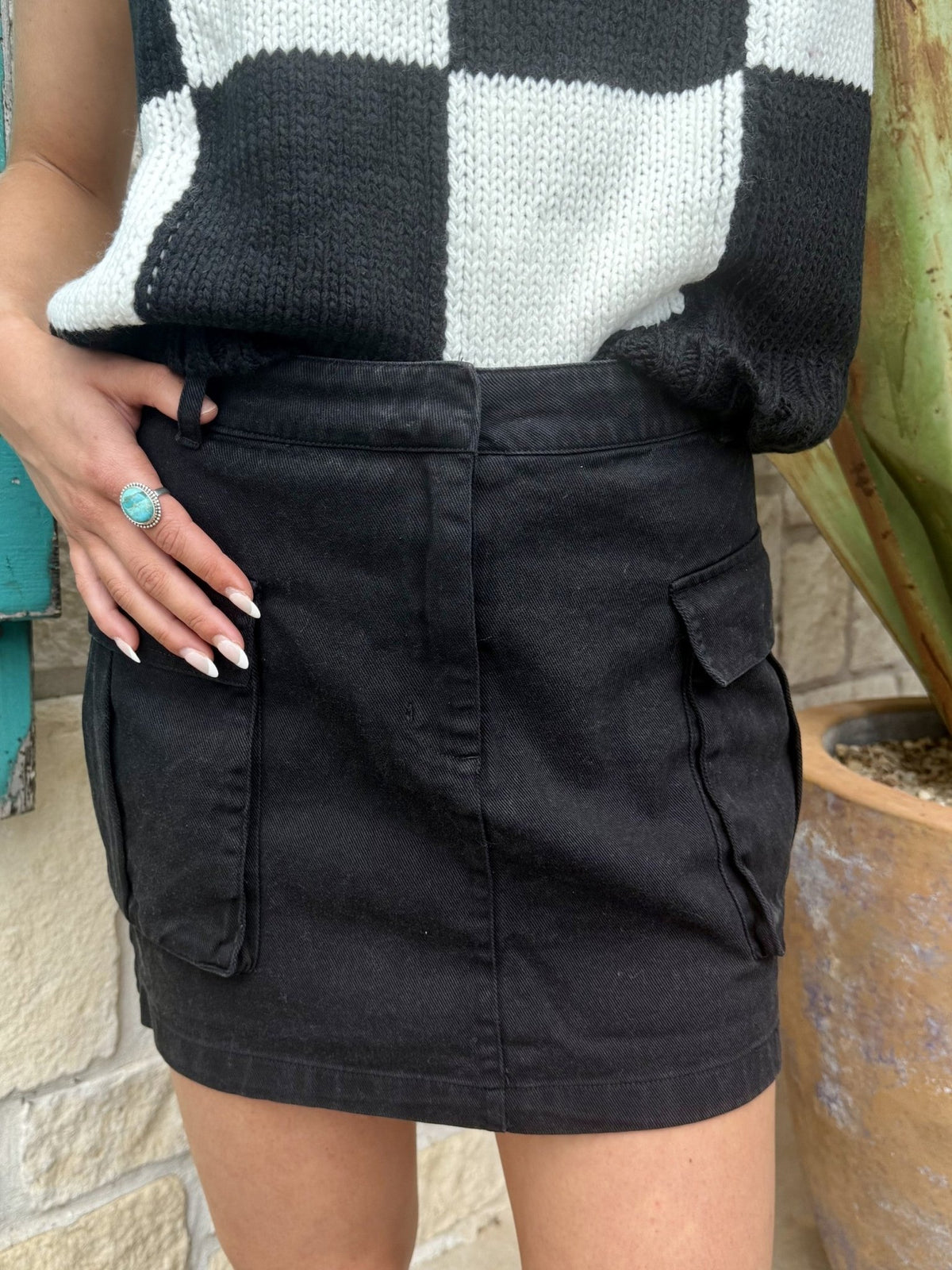 Ladies EEsome cargo mini skirt in black, featuring durable cotton fabric and functional side cargo flap pockets with belt loops for an adjustable fit – DZ25C920. Available at Blair's Western Wear, Marble Falls, TX.