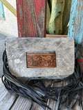 ADBG360ACSL — Women's grey and silver acid-wash splatter hair-on cowhide fringe crossbody clutch with rectangular pale natural tan hand-tooled sunflower and acanthus scroll leather inset centered on the front, long dark navy/black leather fringe on both sides, envelope flap closure, and detachable dark crossbody strap — Blair's Western Wear Marble Falls TX