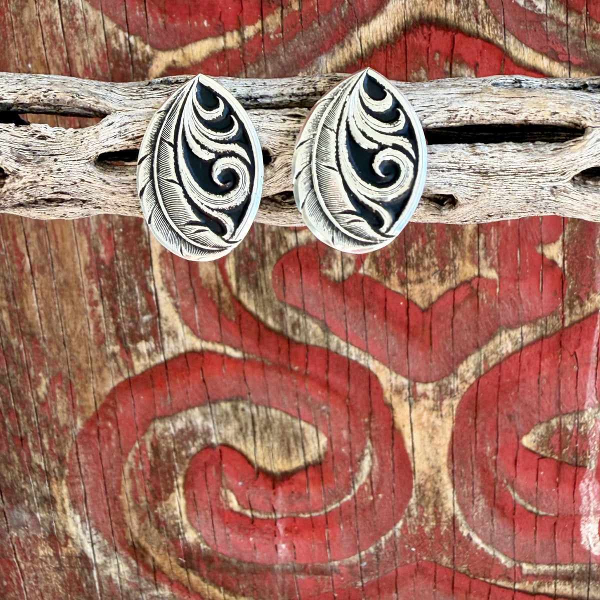 Women's silver-tone teardrop earrings with curved feather motifs, sweeping scroll details, smooth borders, and dark recessed backgrounds — Blair's Western Wear Marble Falls TX