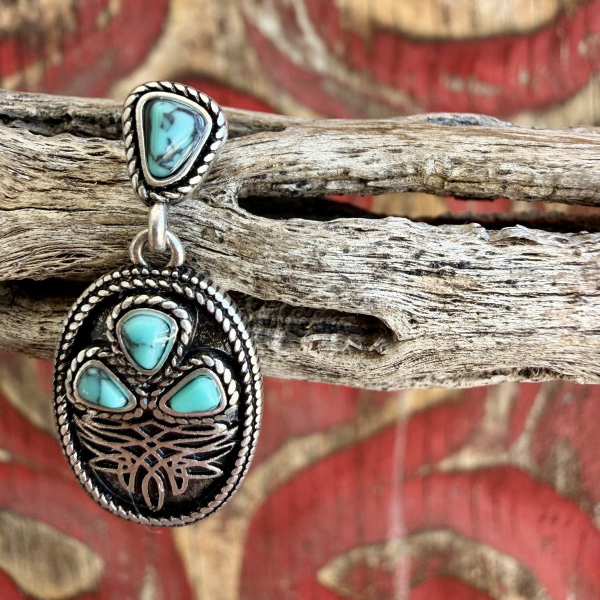 Close-up of silver-tone boot stitch earring with triangular turquoise-colored top, three matching oval-drop accents, and twisted rope edging — Blair's Western Wear Marble Falls TX