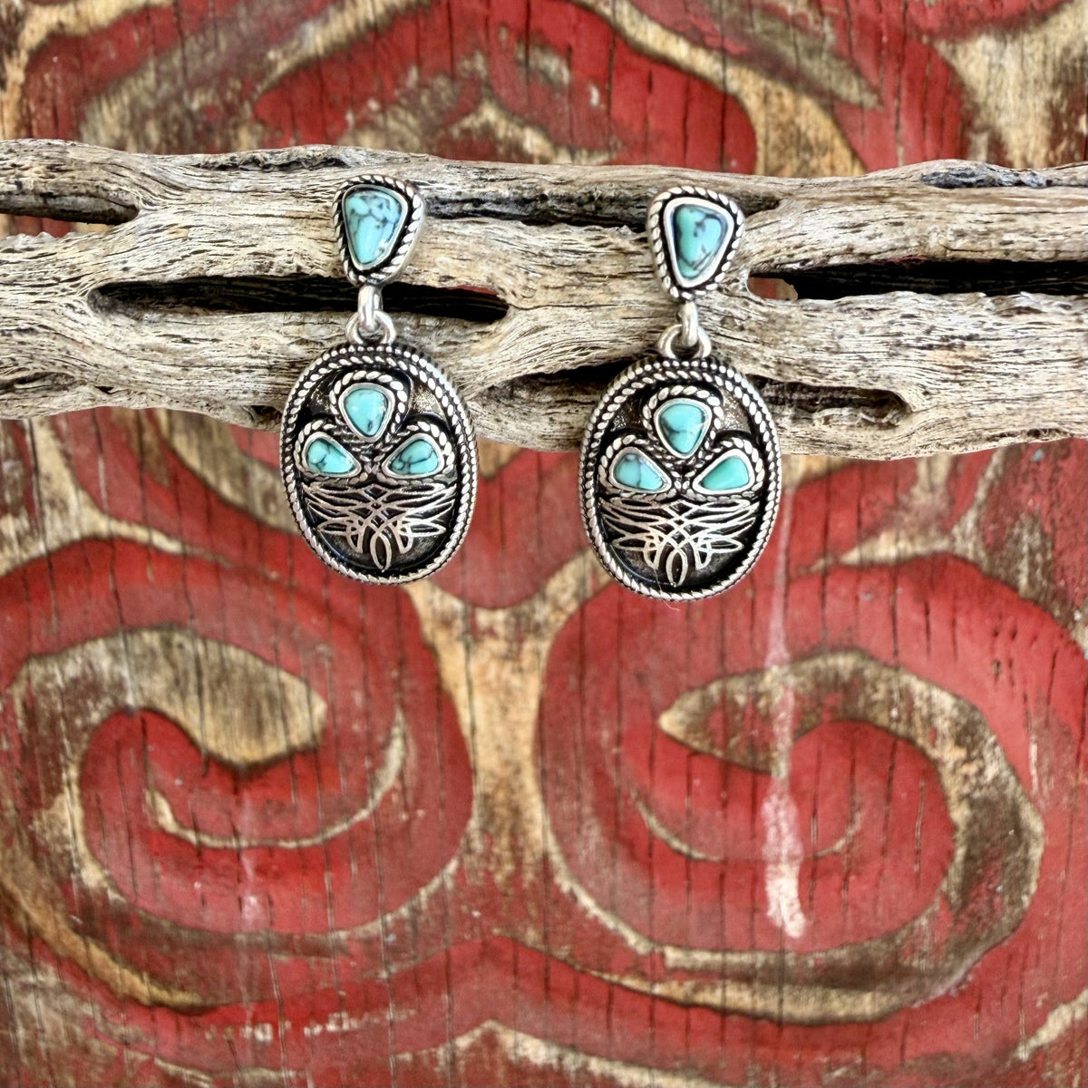 Women's silver-tone oval drop earrings with turquoise-colored triangular accents, rope-style borders, dark recessed backgrounds, and boot stitch motifs — Blair's Western Wear Marble Falls TX