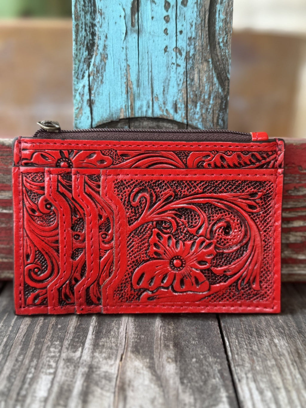 ADBG1506E — Women's rich red hand-tooled leather cardholder wallet showing large floral and scroll motif with dark black antiqued contrast on the front, three fanned card slots on the left panel, and zippered top pouch — Blair's Western Wear Marble Falls TX