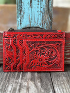 ADBG1506E — Women's rich red hand-tooled leather cardholder wallet showing large floral and scroll motif with dark black antiqued contrast on the front, three fanned card slots on the left panel, and zippered top pouch — Blair's Western Wear Marble Falls TX