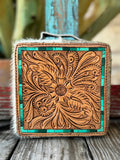 This jaw-dropping jewelry case features a hand-tooled sunflower and feather scroll leather lid in natural tan with a stunning turquoise tile inlay border, wrapped in white and cream natural hair-on cowhide — it's western artisan style that belongs on your dresser — Blair's Western Wear Marble Falls TX