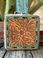 This jaw-dropping jewelry case features a hand-tooled sunflower and feather scroll leather lid in natural tan with a stunning turquoise tile inlay border, wrapped in white and cream natural hair-on cowhide — it's western artisan style that belongs on your dresser — Blair's Western Wear Marble Falls TX