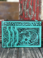  ADBG1506I — Women's vibrant turquoise hand-tooled leather cardholder wallet showing large floral and scroll motif with dark black antiqued contrast on the front, three fanned card slots on the left panel, and zippered top pouch — Blair's Western Wear Marble Falls TX